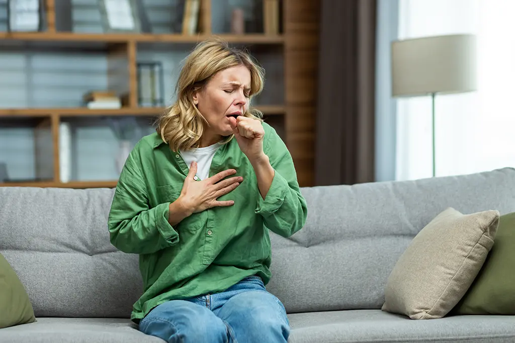 A woman coughing in her household